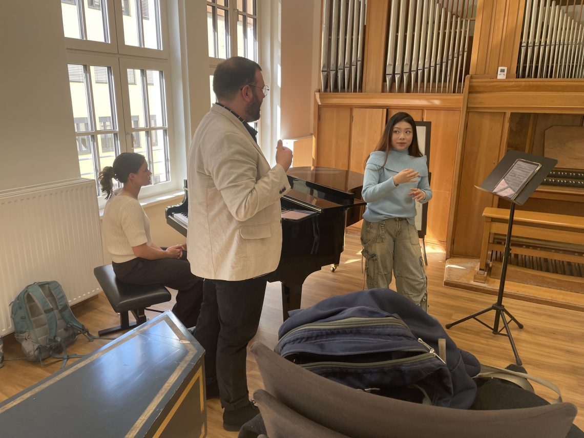 Mackenzie at the piano while Caleb gives critique of a students work.
