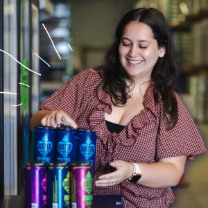 Olivia O'Donnell smiles while handling cans of mainelove water in the warehouse at mainelove's Westbrook facility.