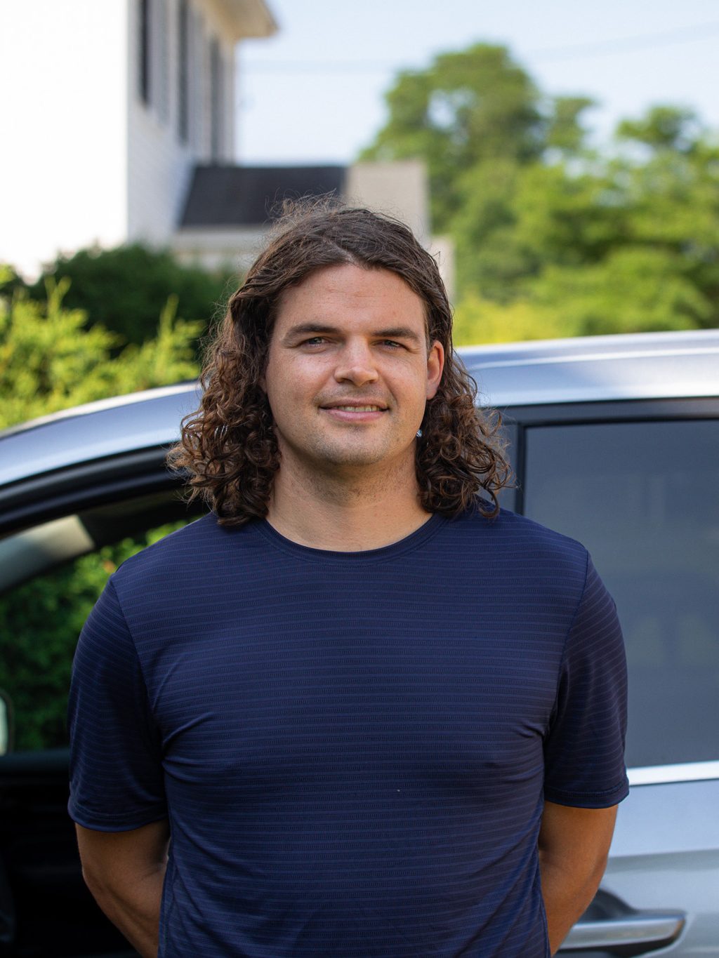 Calvin Soule stands beside the Green Curtain Roadshow van on departure day, smiling.