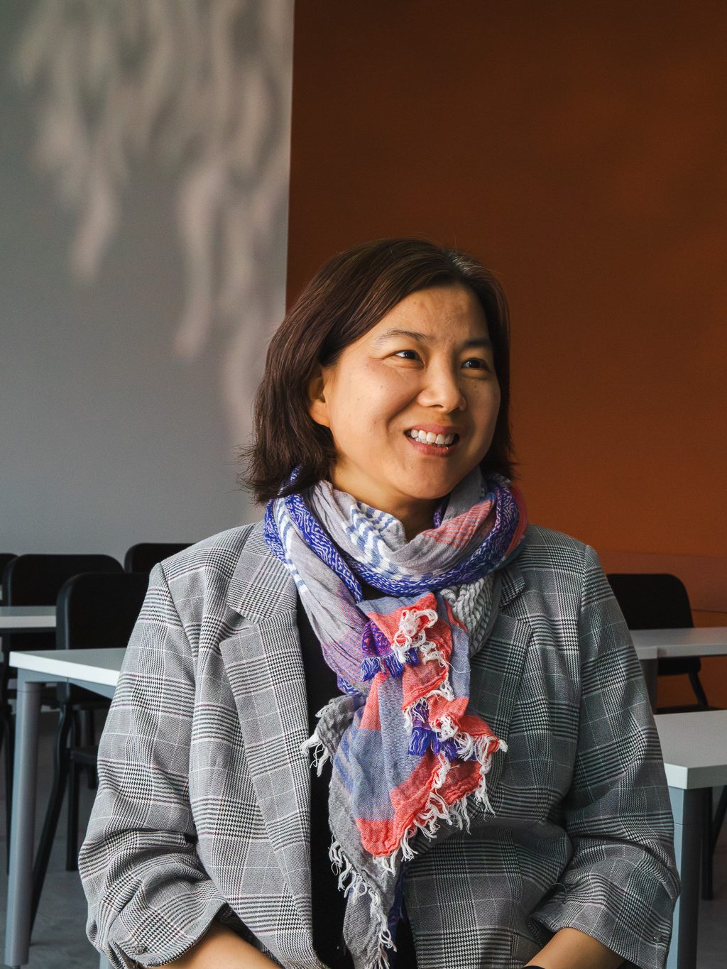 Annie Lee-Zimerle smiles while seated in a classroom space at the Crewe Center for the Arts.