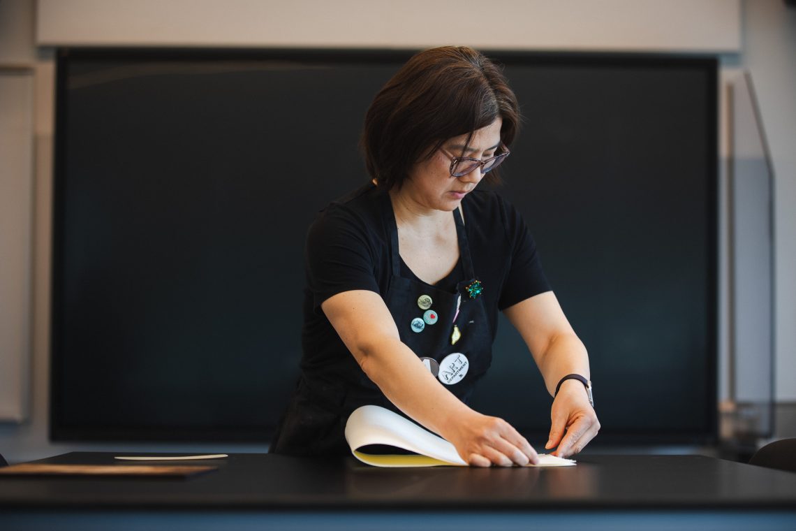 Annie Lee-Zimerle works with paper at a table in the Book Arts studio at the Crewe Center for the Arts.