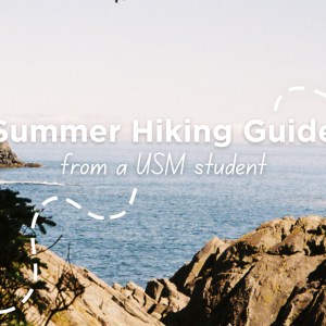 A scenic coastal view from Monhegan Island, ME, with rocky cliffs and pine tree branches framing the calm blue ocean. Text overlay reads "Summer Hiking Guide from a USM student."