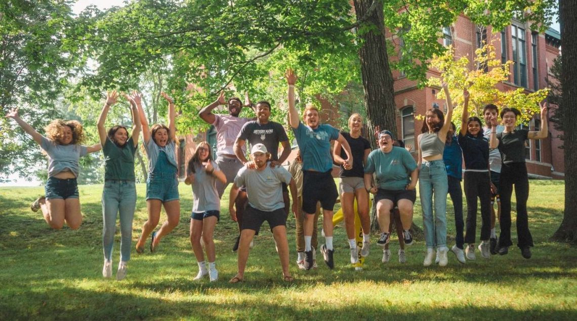 A large group of students jumping in the air together at the same time.