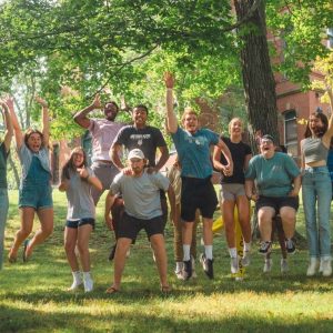 A large group of students jumping in the air together at the same time.