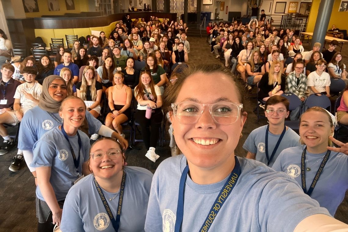Group photo of 2025 Orientation Team with new students behind them in Lower Brooks on the Gorham campus.
