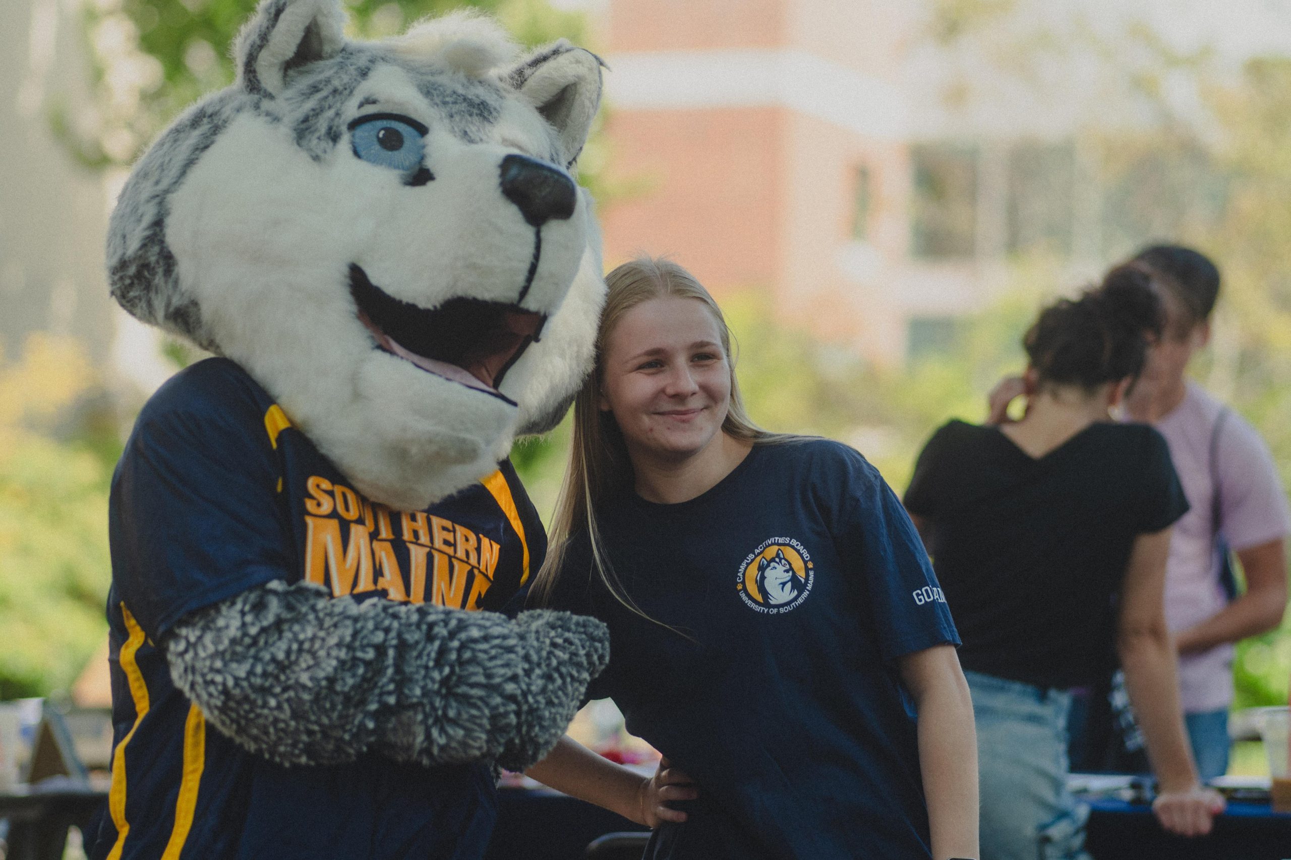 Champ the Husky mascot posing with a Campus Activities Board student at Husky Fest