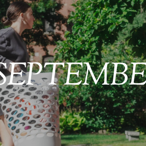 The word "SEPTEMBER" in white text overlaid on a student carrying a laundry basket outdoors on campus