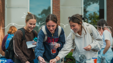 Three students laugh together while browsing items at an outdoor table, with playful hand-drawn accents around them."