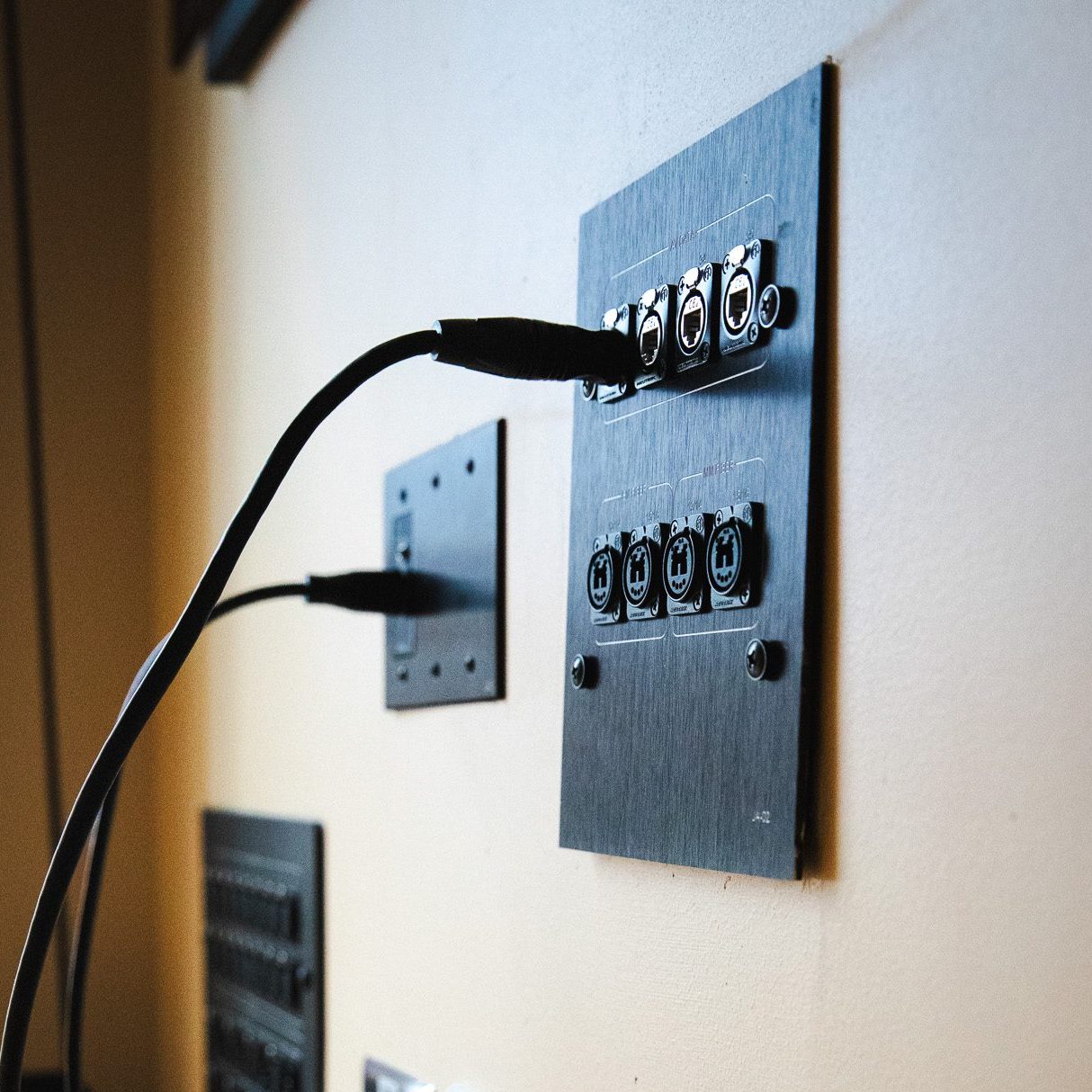 Audio connection panels and cables mounted on a wall in the Crewe Center's backstage area.