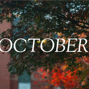 "OCTOBER" text overlaid on red and orange fall foliage framing historic brick building on USM campus