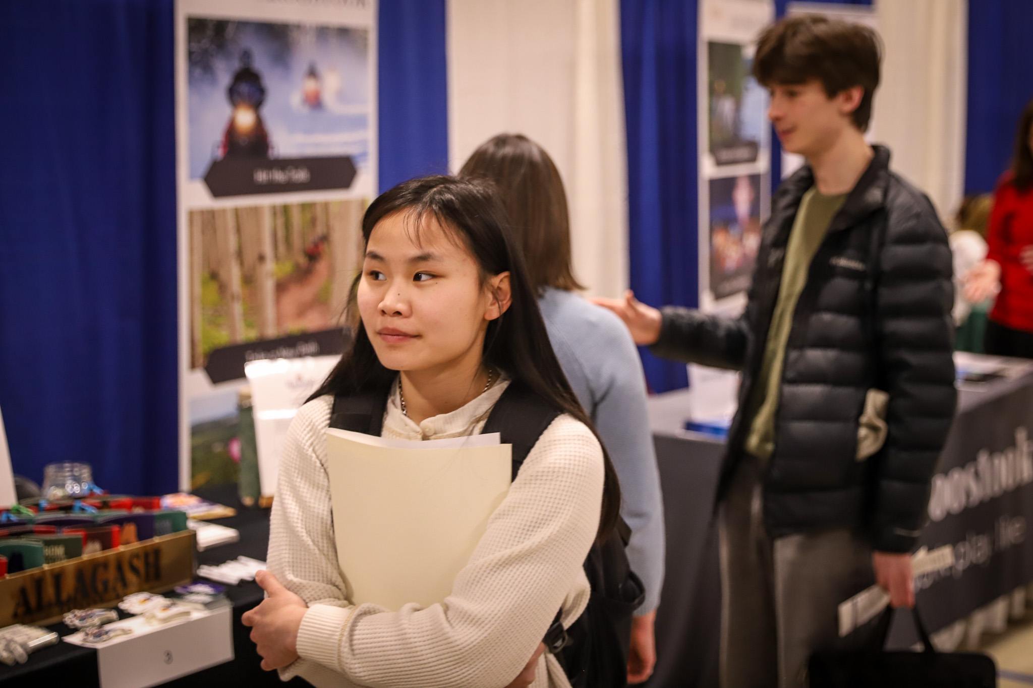 USM student holding resume folder at Fall Job and Internship Fair on Portland campus