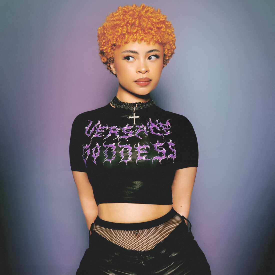 Ice Spice, musical artist, stands in a black t shirt looking to the side of the camera