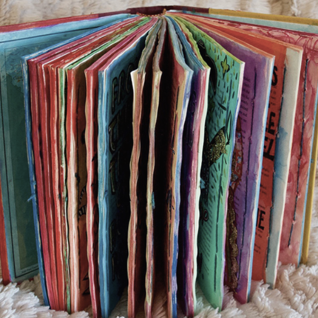 El Toro, Repurposed book, by Art Student Olivia Dyer. A book with colorful pages is displayed with the spine facing backward, and the pages facing the viewer. 