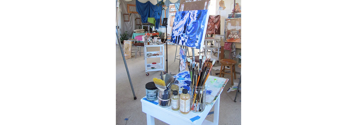 An image of an easel with paint on it and a painter's workstation