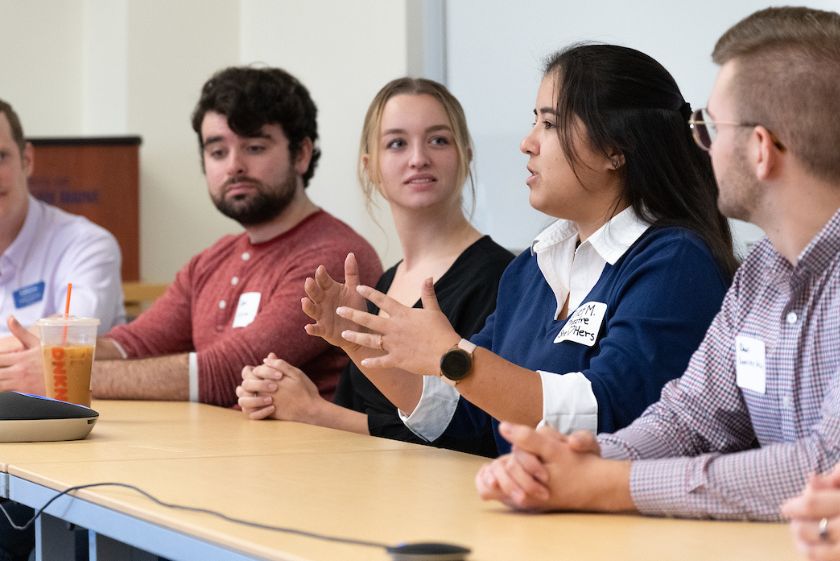 USM students sitting at a panel discussion, student in the middle is speaking.