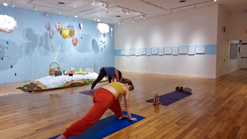 Individuals participating in yoga in a Gallery