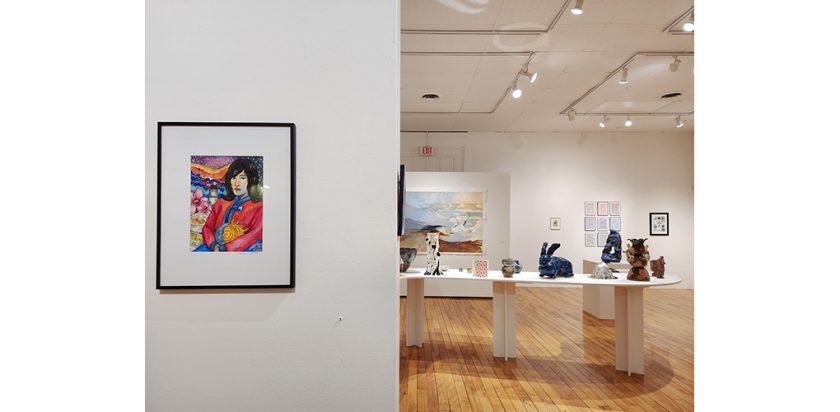 A Gallery with a watercolor in the foreground and ceramics on a table in the background.