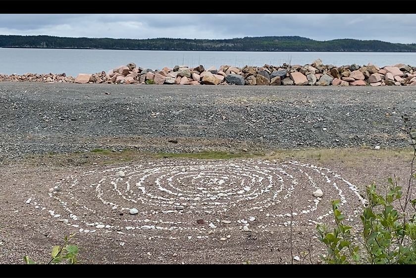 A circle of stones on the ground of a coast line