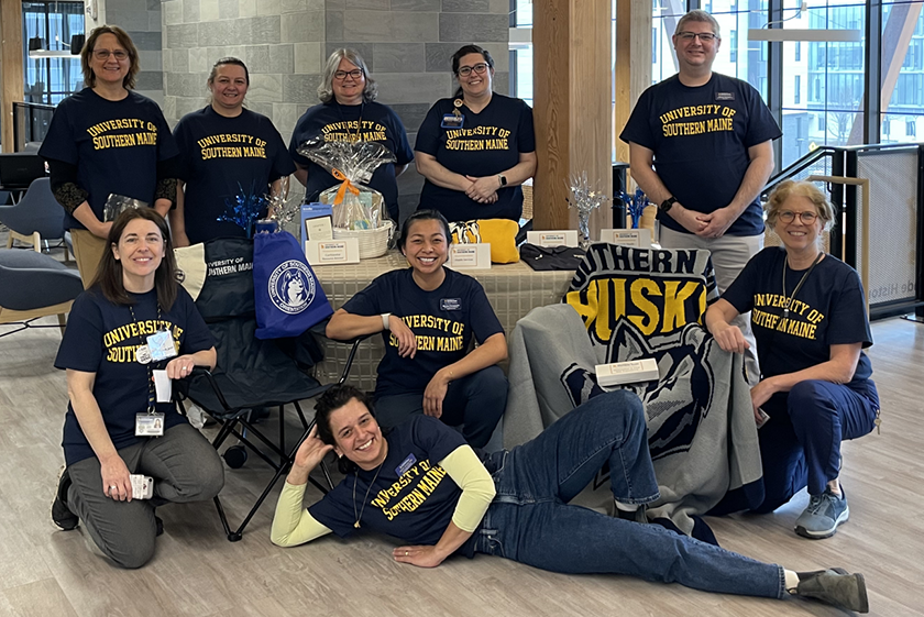 Several people wearing USM gear pose for a photo in our McGoldrick Center.