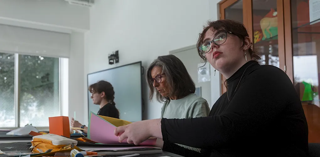 Three students are working individually on projects in the Kate Cheney Chappell ’83 Center for Book Arts space.