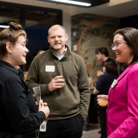 Two students talking with a Unum representative during the mocktail hour at the Networking dinner in McGoldrick.