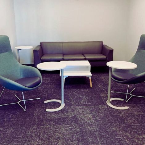 Image of the employer lounge in the Career & Employment Hub office, a couch in the center with two chairs in front of two side tables.