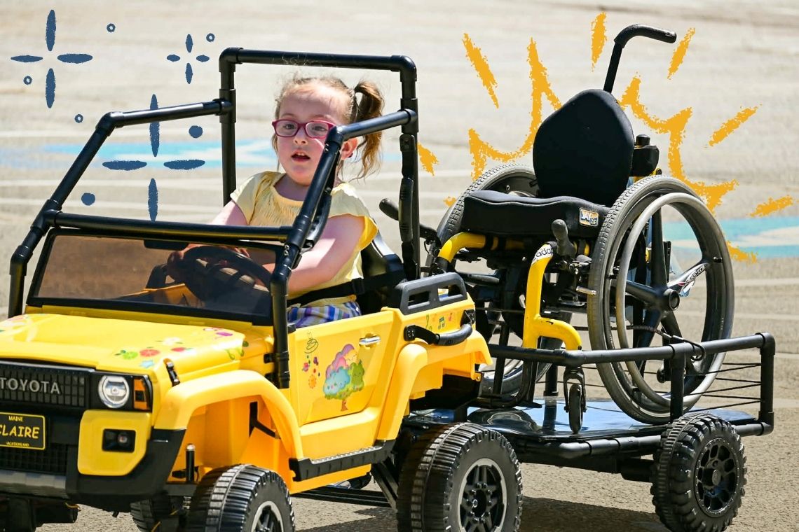 Clare driving in her newly adapted toy car created for her through Go Baby Go and USM.