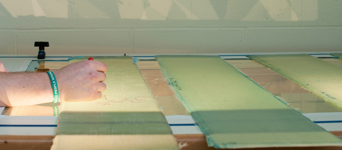 An engineer marking a technical design at an illuminated drafting table