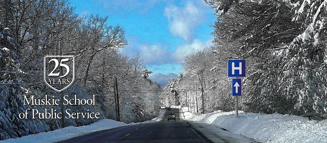 A rural road running through a snow covered, forested area with a hospital sign pointing ahead and the "25 Years" Muskie School of Public Service logo overlayed