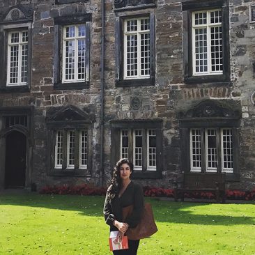 Image of Alexa McCarthy in front of a stone building.