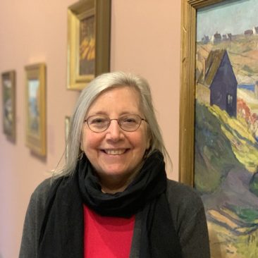 Photo of Donna Cassidy in front of Paintings at the Ogunquit Art Museum