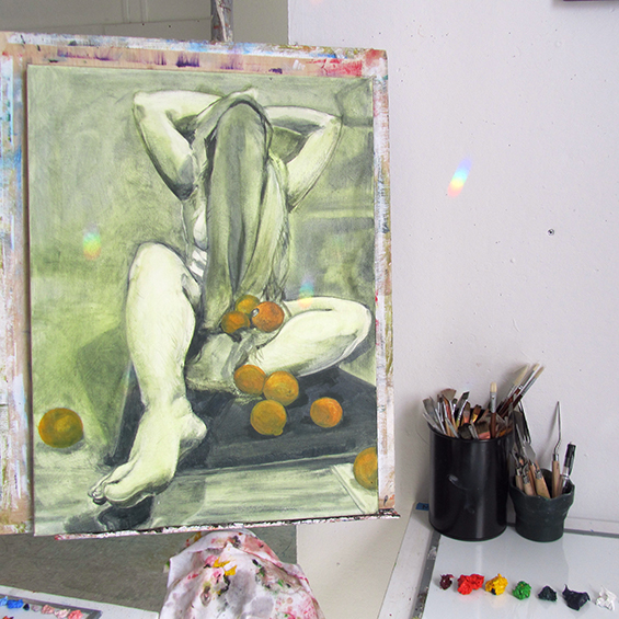 Painting in process by BFA student Rose DiMuzio. Painting of seated figure with oranges in alap and head and front covered with cloth.