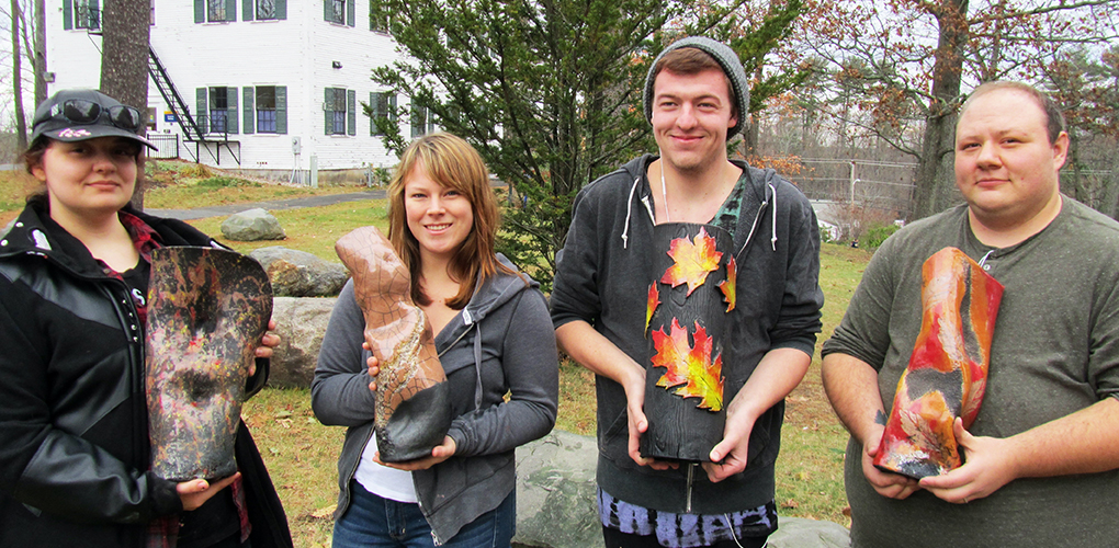 Four Ceramic students show off their raku fired hand-built vases in Autumn.
