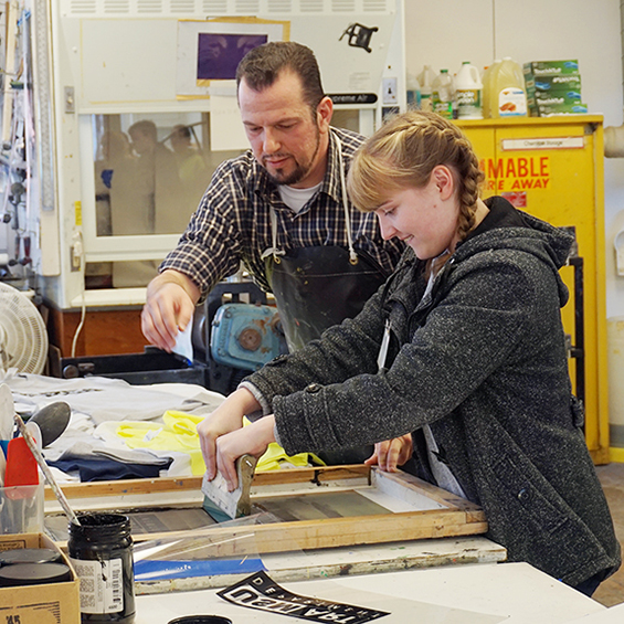 Art Faculty Instructs Art student with Printing a Silkscreen