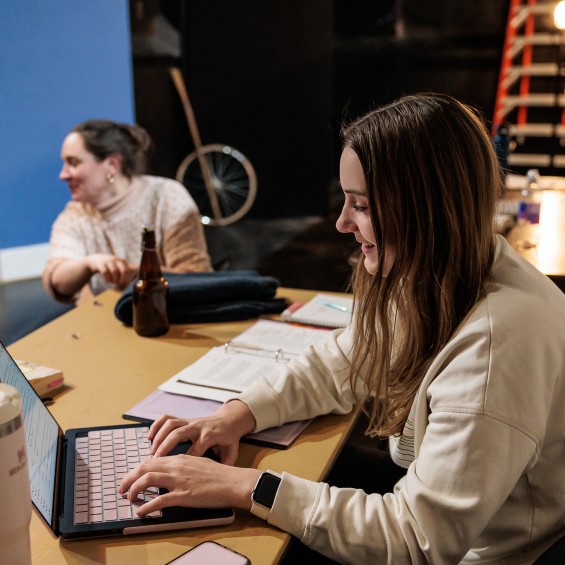 Student working on a computer at a rehearsal.