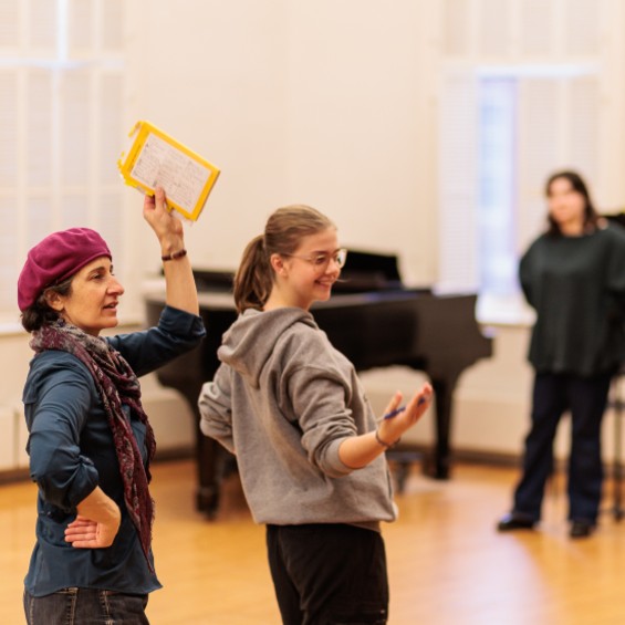 Teacher directing a student during a play rehearsal.