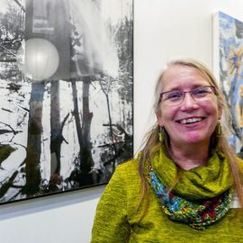 Picture of Amy Hagberg in front of one of her pinhole photographs at Gallery opening.