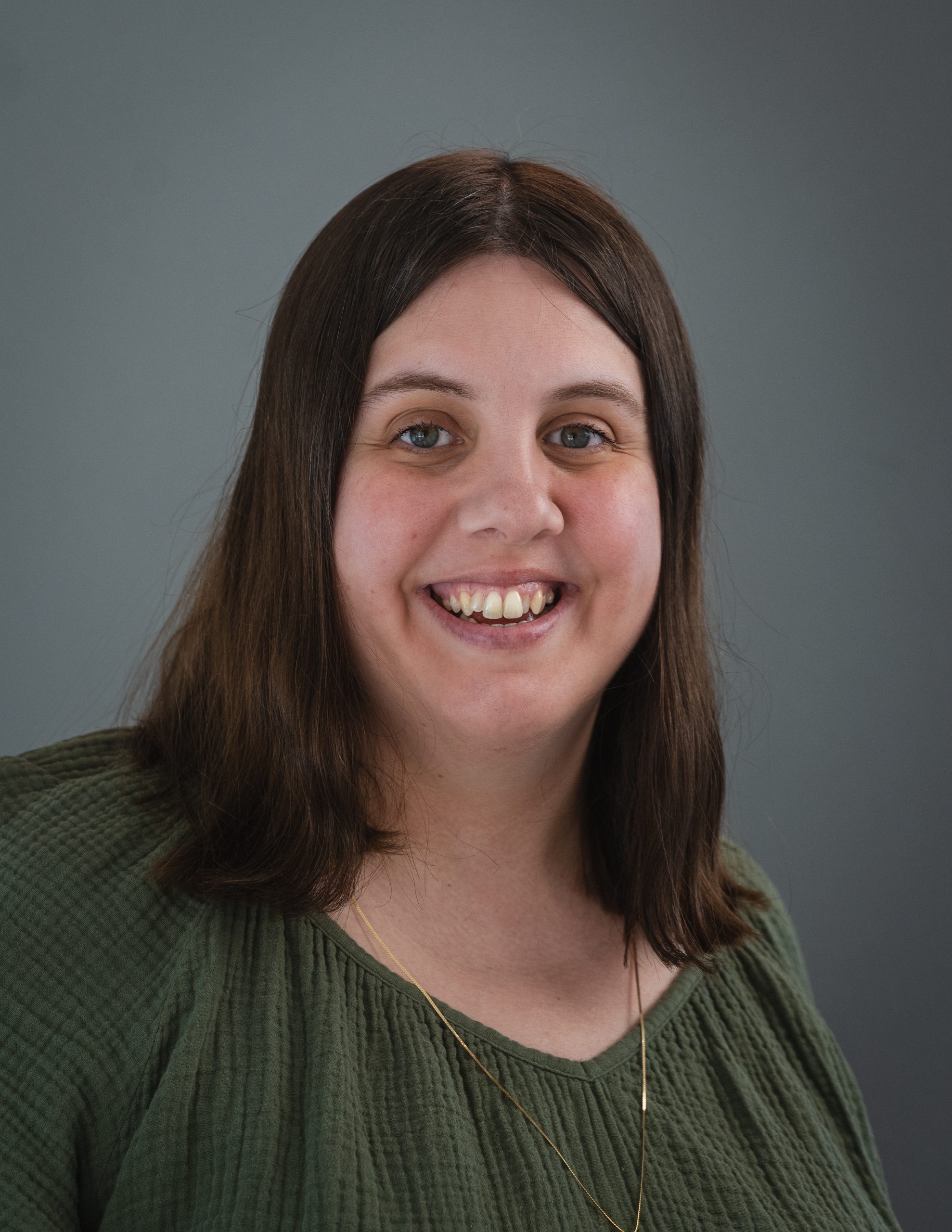 Photo of Lindsay Larsen. Lindsay has brown hair and is wearing a green top.