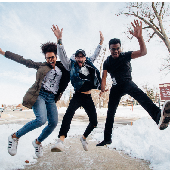 Three friends jumping outside in the snow. Photo by Zachary Nelson for Unsplash