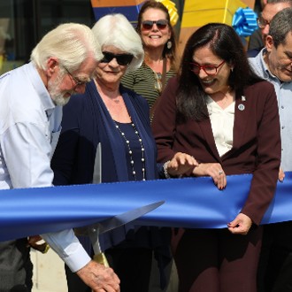 Dick and Carolyn McGoldrick wield the scissors at the ribbon-cutting ceremony for the McGoldrick Center.