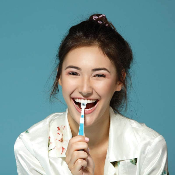 image of college student brushing her teeth