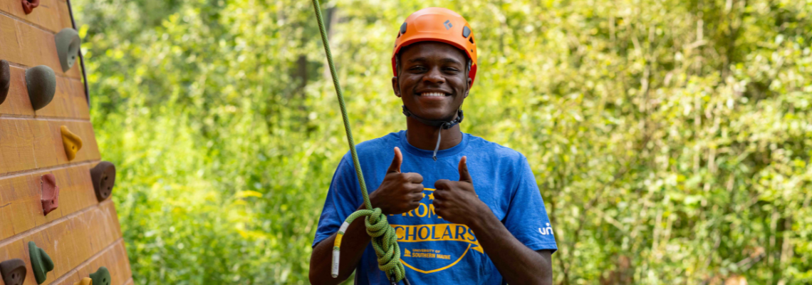 Promise Scholar during Immersion Week completing the climbing wall challenge