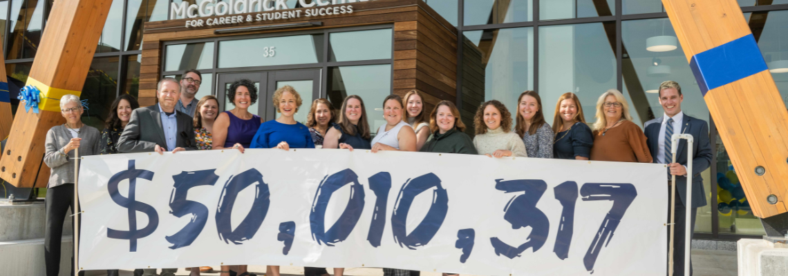 USM Foundation staff holding $5,000,000 Great University Campaign banner