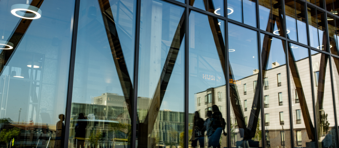 reflection of students in McGoldrick windows