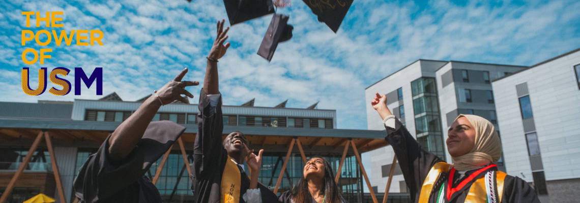Grads on Bean Green throwing hats in the air