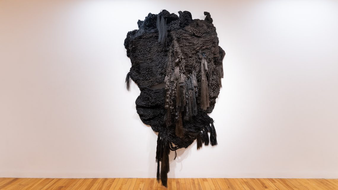 Veronica A. Perez, "who’s gonna take care of me...when you die," 2023. Artificial hair, bobby pins, 125 in. tall x 96 in. wide x 27 in. deep. Part of shadow / echo / memory, University of Southern Maine Art Gallery, 2023. Photo: Jack Stolz.