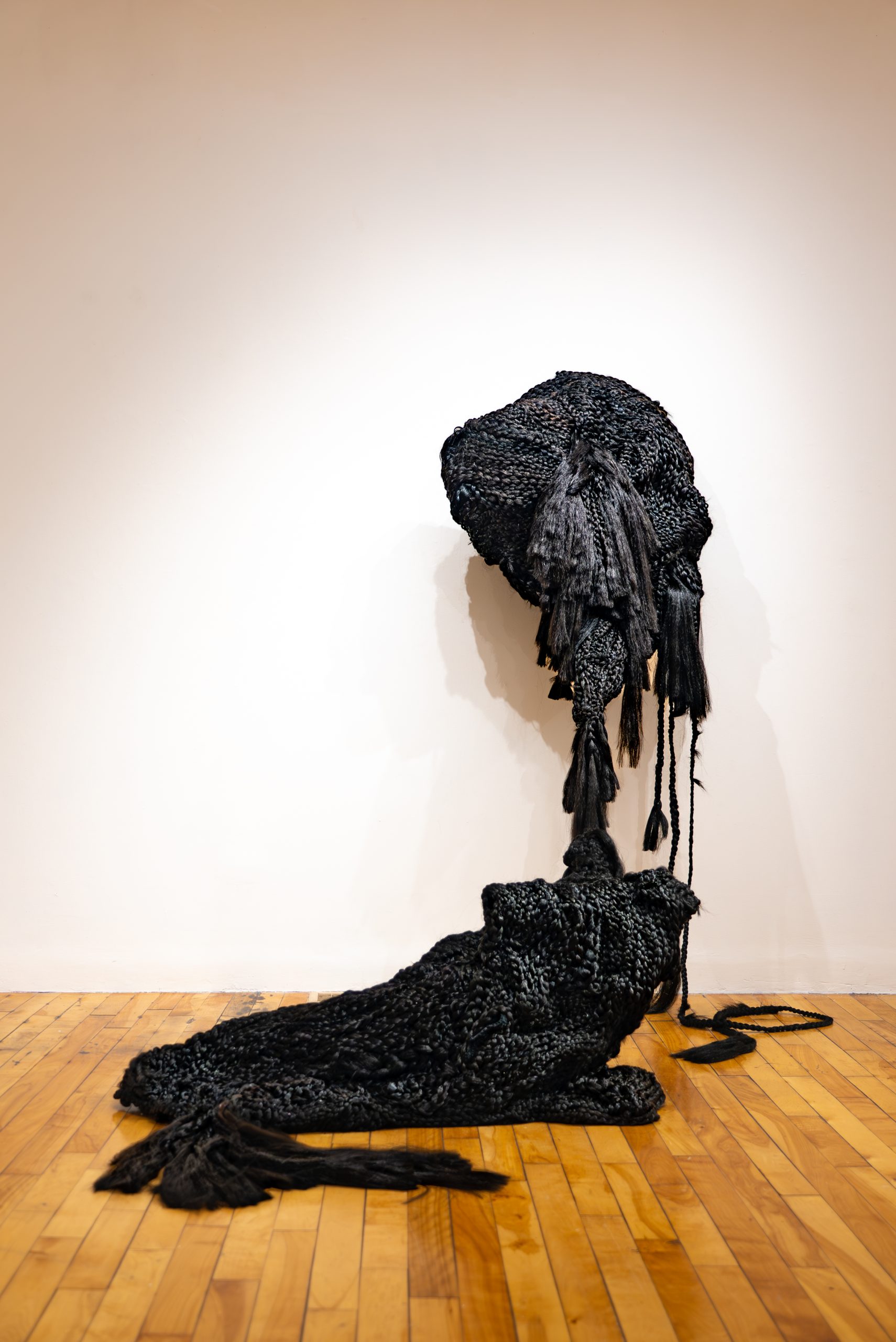 Veronica A. Perez, "ecotone/echotone," 2023. Artificial hair, bobby pins: wall piece; 79 in. tall x 40 in. wide x 36 in. deep; floor piece; 26 in. tall x 48 in. long x 25 in. deep. Part of shadow / echo / memory, University of Southern Maine Art Gallery, 2023.