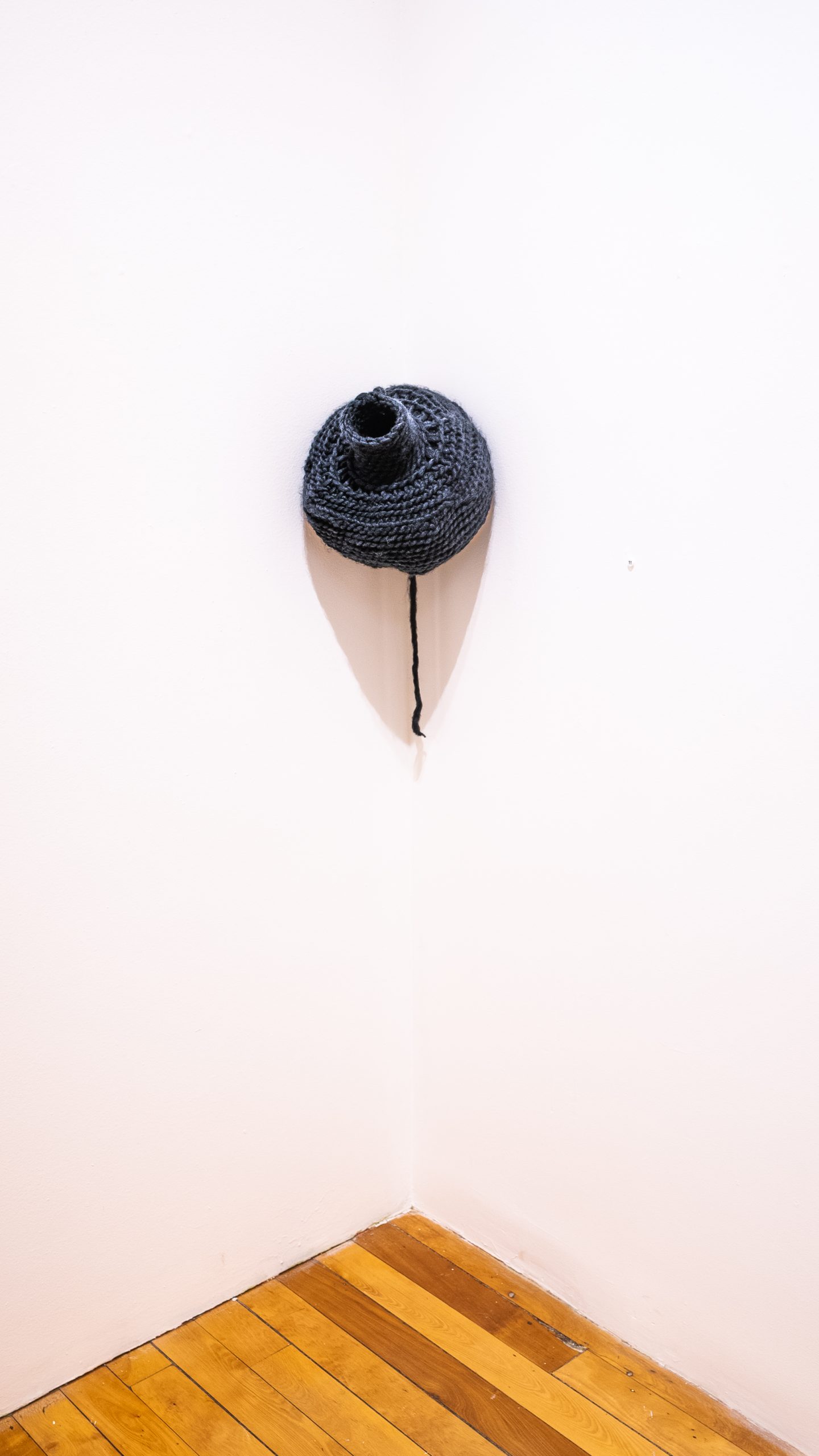 Veronica A. Perez, "autonomy through confinement," 2023. Yarn, artificial hair, 10 in. high x 12 in. wide x 6 in. deep. Part of shadow / echo / memory, University of Southern Maine Art Gallery, 2023.