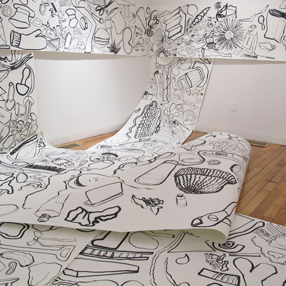 An image of an extremely large piece of paper rolled and sprawling out over a gallery space with marker drawings