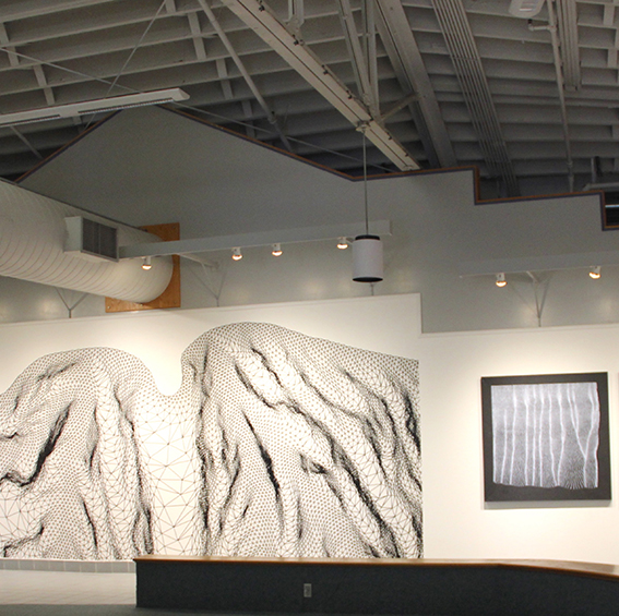 An image of a gallery with a large drawing of a mountain on the wall